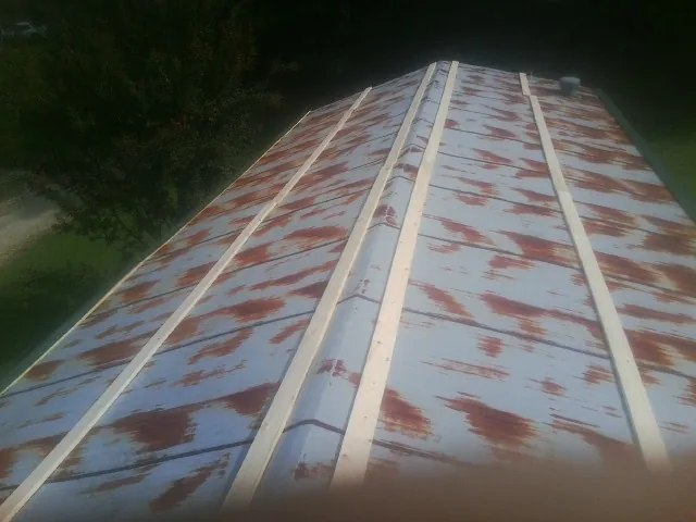 Rusted metal roof panels with new wood purlins before replacement — Storm Damage Roof Repair in Atwood by Roofing Brothers